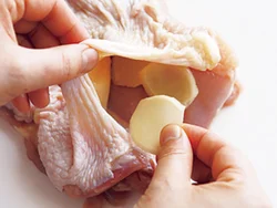 とり肉の皮を少しはがし、身との間にしょうがを詰めていく。重なってもよいが、なるべくまんべんなくいきわたるように詰めて。