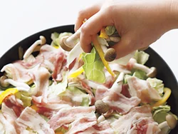 フライパンに野菜、豚肉の順に広げて重ね、さらにこれをもう１回繰り返して蒸し焼きにすることで、肉のうまみがいきわたる。