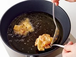 たねは大きめのスプーンですくい、滑らせるように油に落とし入れるときれいな形に仕上がる。