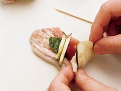 塩をふってしんなりしたなすに豚肉を重ね、バジル、トマト、余ったなすをのせて巻く。なすが豚肉の脂を吸っておいしくなる。