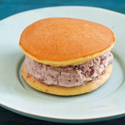 【ミニどらアイスサンドに】
ミニどら焼きは、卵1個、きび砂糖50g、みりん小さじ1、水1/4カップを泡立て器でよく混ぜ、薄力粉80g、ベーキングパウダー小さじ1/2を合わせてふるい入れ、粉っぽさがなくなるまで混ぜて生地を作る。フライパンに太白ごま油を薄くひき、生地を大さじ1を目安に流して円く広げ、両面色よく焼く。生地をさまして、あずきみるくアイス適量をはさみ、ラップに包んで冷凍庫で冷やす。