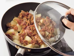 野菜の上に牛肉を広げ入れ、酒を加えて蒸し焼きにすることで、牛肉がかたくなるのを防ぐ。