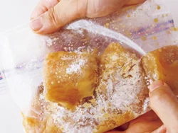 和風だれをきり、袋に片栗粉を直接入れ、かじき全体にまぶす。表面に粉っぽさが残る程度を目安に。