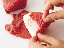 肉におにぎりをのせたら、ご飯が見えないように巻いていく。焼くと肉が縮んでしまり、はがれにくくなる。