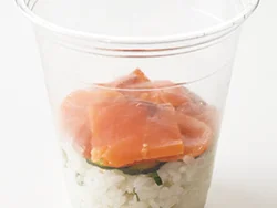カップにご飯、きゅうり、サーモンか生ハムを順に入れていく。ご飯は少しぎゅっと押しながら詰める。