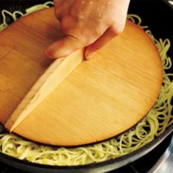 鍋ぶたや木の落としぶたなどを使って、フライパンに麺をしっかりと押しつけながら片面をじっくり焼く。油をなじませてあるので、焼き色がつく。