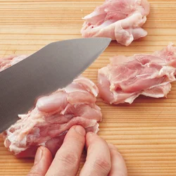 とりもも肉はそぎ切りに。肉の厚い部分に斜めに包丁の刃を当てて、薄く切る。断面が広くなるので、早く火が通る。