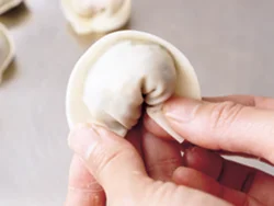 餃子の皮のまん中にあんをのせ、半分に畳んでから、くるりと丸め、両端をくっつける。一口大で食べやすい。