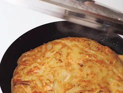 ふたをして蒸し焼きにし、じゃがいも、玉ねぎにしっかりと火を通す。上下を返すときは、ふたや皿を利用して。