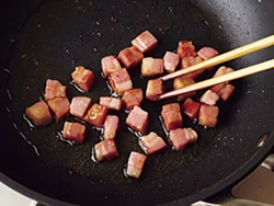 弱火でベーコンを焼き色がつくまでじっくりと炒めて。油にうまみや香りを移し、その油できのこを炒める。