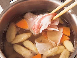 煮立っただし汁に和風根菜ミックスを加え、再び煮立ったときが豚肉を加えるタイミング。