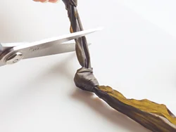 だしをとる昆布を結び昆布にして具としても食べる。昆布は水でふやかし、端から結んで切っていく。