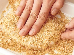 蒸し焼きにした豚肉に水溶き小麦粉を薄くぬり、いったパン粉をまぶす。側面までしっかりと手で押しつける。