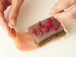 豚肉に具をのせ、畳むように巻く。巻き終わりが角に来ると、蒸し焼きにしたときにばらけやすくなるので注意。