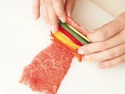 牛肉を広げ、パプリカ、万能ねぎを手前にのせて巻く。野菜の長さを揃えて切ると、きれいな仕上がりに。