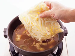 汁ができてから、うどんを加えて煮る。菜箸でほぐして固まらないようにする。