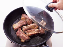 厚みのあるスペアリブは、全体を焼きつけたあとにワインで蒸し焼きにして中まで火を通して。