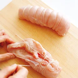 肉の上にたこ糸を横一文字に置き、それを巻き込むようにしながらくるくるときつく巻く。