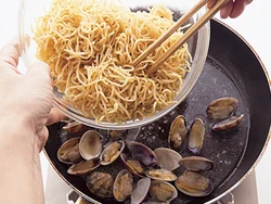 あさりの口があき、だしが出たところに麺を戻し入れ、貝のうまみを麺に吸わせて。