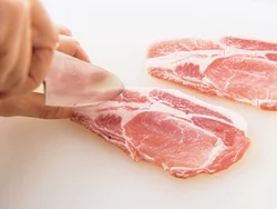 肉を横長に広げ、赤身と脂身の間のほか、肉の上下にも切り目を入れると焼き縮みしづらい。