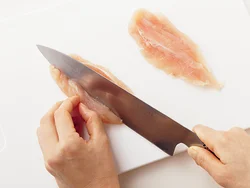 ささ身の厚みが半分になるように、包丁を斜めにして左右に切り目を入れて開く。