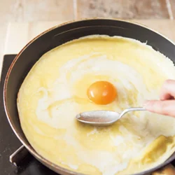 卵を中心に割り落としたら、大きめのスプーンの背を使って、白身を全体に薄くのばして広げる。