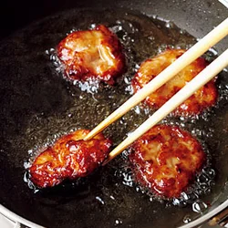下味をつけた薄切り肉を円く平らにして、中までしっかり火が入るように揚げ焼きにする。