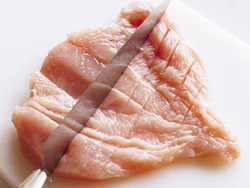むね肉は一口大に切る前に包丁の背でたたき、繊維を断ち切ってやわらかくする。