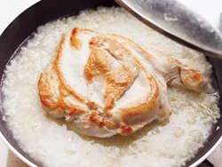 皮目をこんがり焼いたむね肉を米にのせて、蒸し煮にする。スチームでふっくら火が入る。