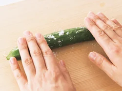 両端を切り落とし、塩小さじ1/2〜1をまぶしてまな板の上で転がす。塩が全体になじんだら、水洗いする。