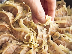 チーズは餃子のすき間に散らし、溶けて餃子の底面全体にいきわたるようにする。じっくり焼いてカリカリに。