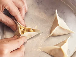 餃子の皮にあんをのせ、皮の縁の三方を中央に寄せて、しっかり閉じる。揚げると皮がカリッとして美味。