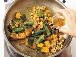 カレー粉は最初は味つけに、２回目は香りと風味をつけるために分けて加える。
