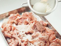 小麦粉は茶こしに入れて豚肉にふり、さらに豚肉をほぐしながら全体にまぶし、味がよくからむようにする。
