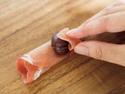 小さいタイプの生ハムを三つ折りにし、甘栗をのせて巻くだけ。端は留めなくても、自然とくっつく。