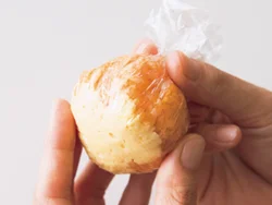 ラップに、卵、ケチャップライスの順にのせ、茶きんに絞る。