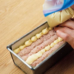 型のすき間やハート形模様になるケーキのすき間など、すき間ができやすいところに生地を絞り出す。上部は押しつけずさっとならすくらいにすると、きれいな模様に仕上がる。