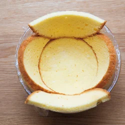 スポンジケーキの輪切り1枚は底に敷き、2枚は半月形に切ってすき間ができないように沿わせ、クリームを詰めてから、残りの1枚でふたをする。