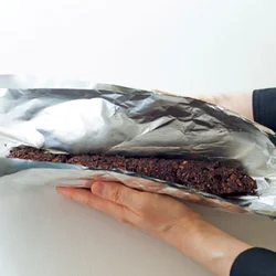 アルミホイルは破れやすいので二重に包む。アルミホイルの上から形づくるとシワがサラミのように。
