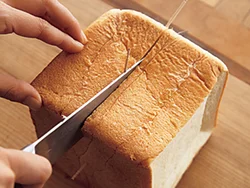 食パン1斤(スライスしていないもの)の厚みを半分に切る。切る位置につまようじを刺してから切ると、きれいに切れる。