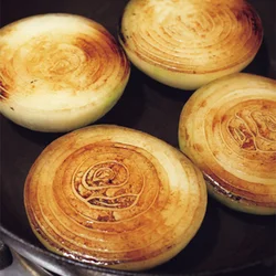 新玉ねぎの甘くてやわらかなうまみを閉じ込めるべく、まずは表面を焼き、それから蒸し煮にするのがコツ。