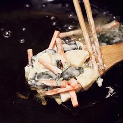 具材を木べらにのせたら少し寄せてまとめ、揚げ油にそっと入れることで、バラバラになりにくくする。
