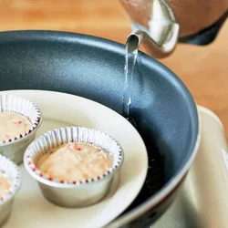 フライパンと皿を使えば蒸し器要らず。皿の下にぬれぶきんをかませてグラつきを防止。湯が皿や生地にかからないよう気をつけて。
