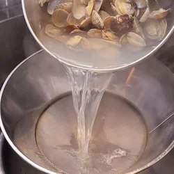 あさりの割れた殻などが煮汁に混ざらないように、こし器を使う。なければざるでもよい。