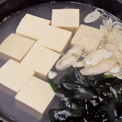あさりのだしで豆腐とわかめを煮て、うまみをしみこませる