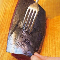 皮目にフォークで穴をあけて火通りをよくする