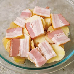 じゃがいもは加熱前にマヨネーズを混ぜておくと味がよくなじむ。さらにベーコンをかぶせてコクをプラス。