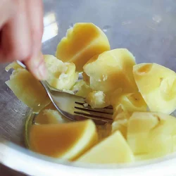 竹串がすっと刺さるようになったら、熱いうちにフォークで潰す。