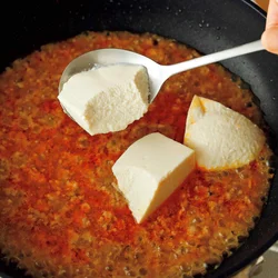 豆腐をすくうと、断面が大きくなって味が入りやすくなる。