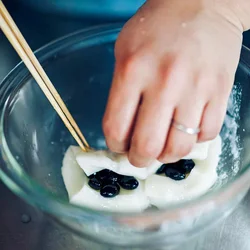 もちに黒豆をのせ、半分に折るように押さえて閉じる。